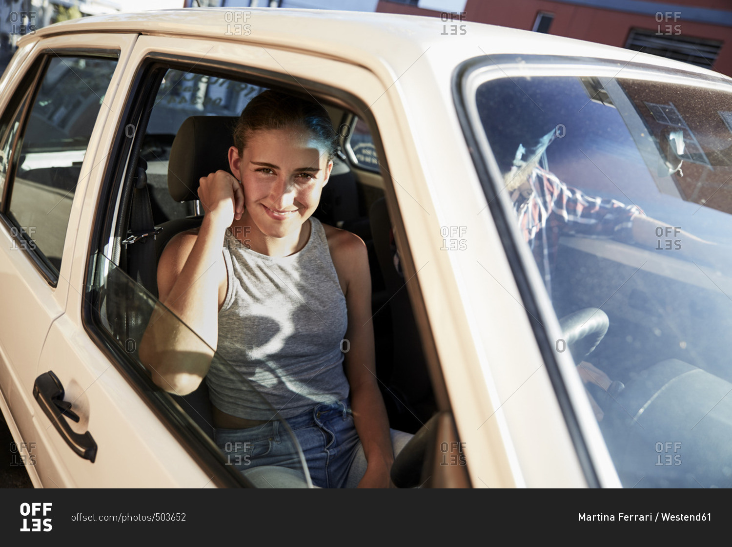 Portrait of smiling young woman looking out of car window