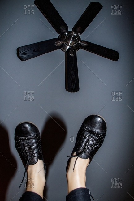 Person holding feet up to ceiling fan