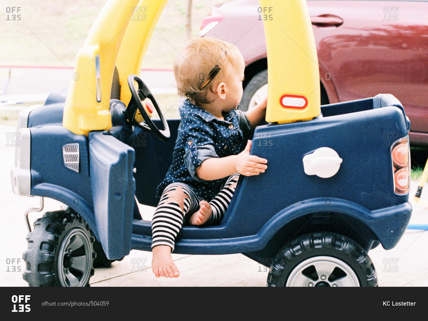 Toddler girl in a push car