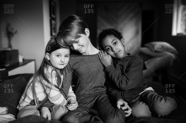 Three multi racial siblings sitting together