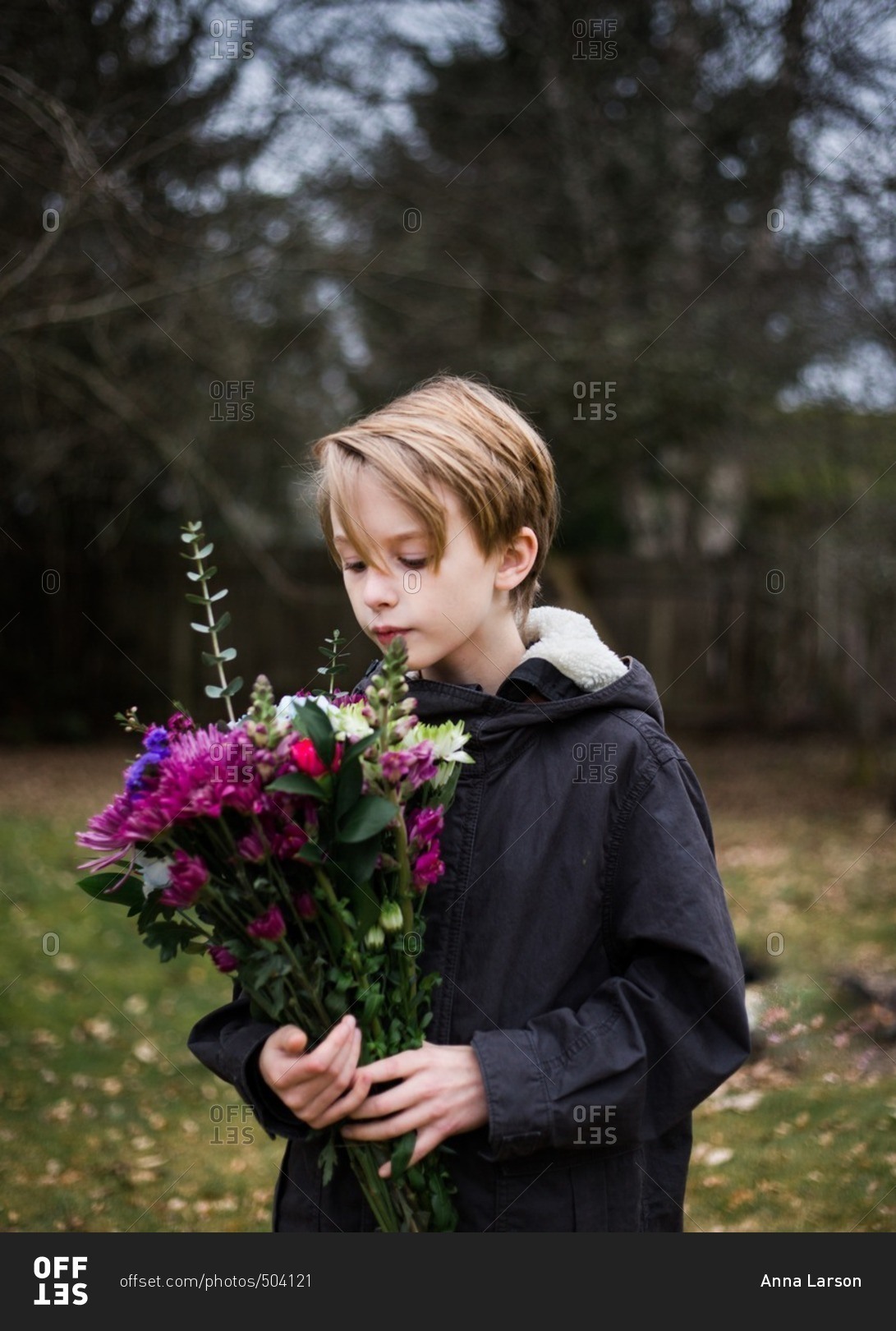 Boy looking at flower bouquet outside