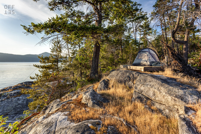 The sun sets on a kayaker's tent on West Curme Island in Desolation Sound Marine Park, British Columbia, Canada