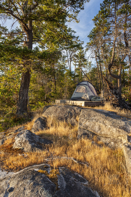 The sun sets on a kayaker's tent on West Curme Island in Desolation Sound Marine Park, British Columbia, Canada