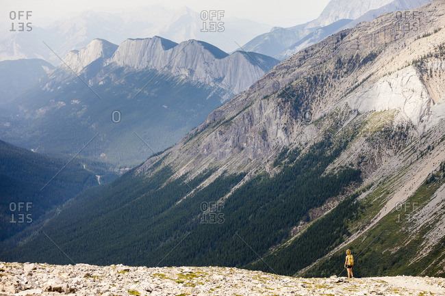 A young woman hikes the Sulphur Skyline Trail with a view of Ashlar Ridge Miette Hot springs, Jasper National Park, Alberta, Canada