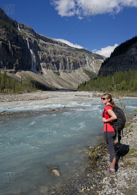 British Columbia, Canada - September 8, 2013: An attractive young lady takes in the views of the 'Valley of a Thousand Falls' while on the Robson trail system of Mount Robson, just North of Valemount, in the Thompson Okanagan region