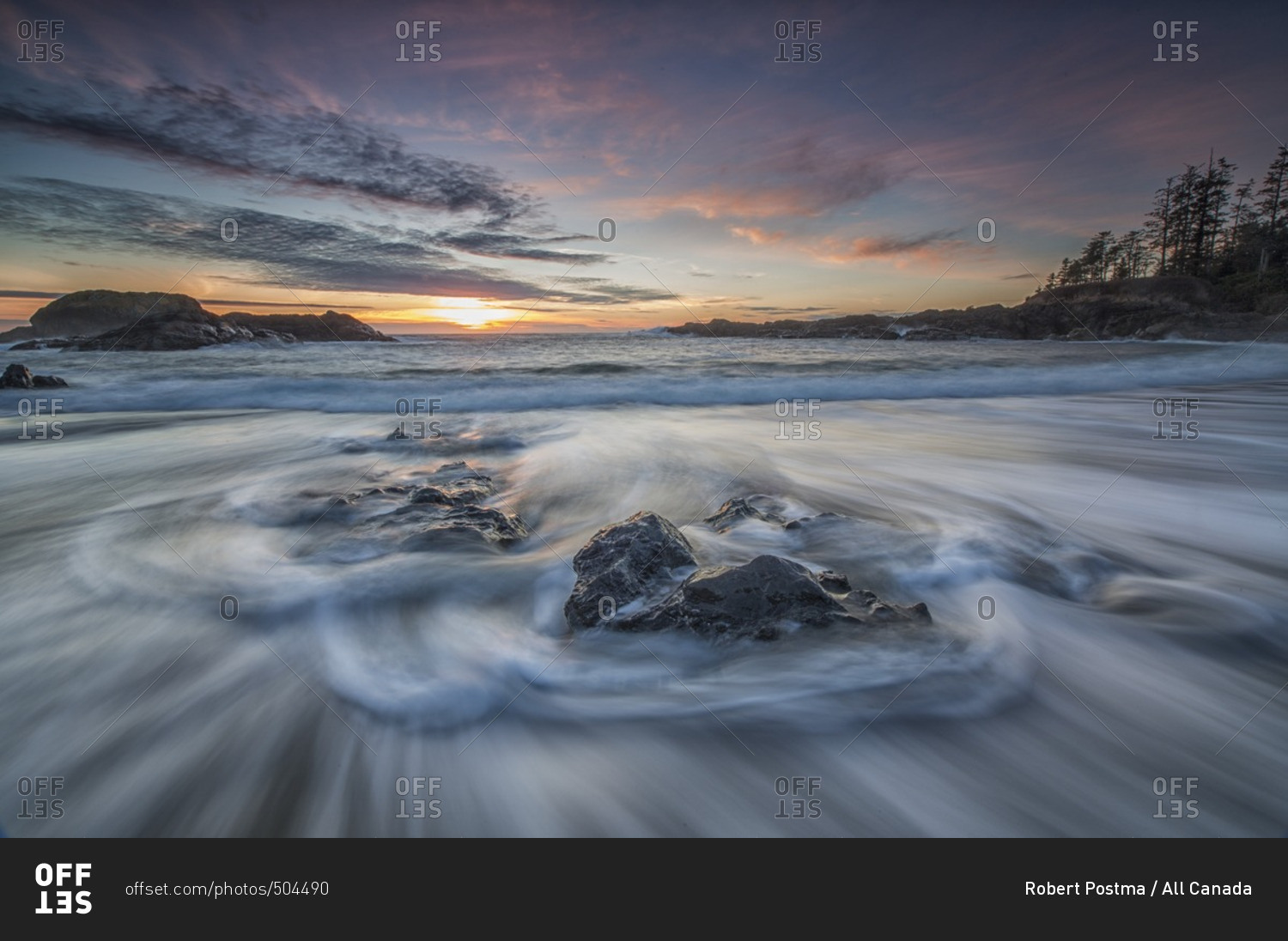 Water flows around the rocks of South Beach as high tide and sunset approaches, Pacific Rim National Park, British Columbia, Canada