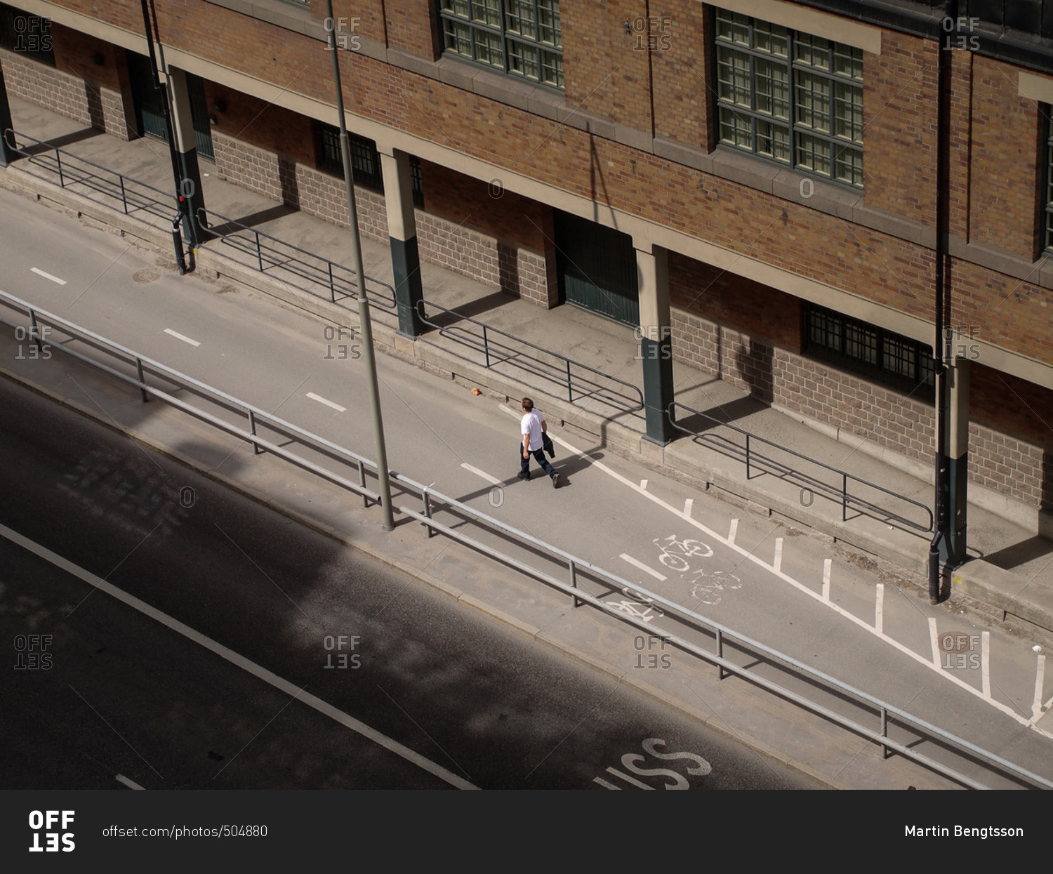 Man walking in a bike lane on an empty city street