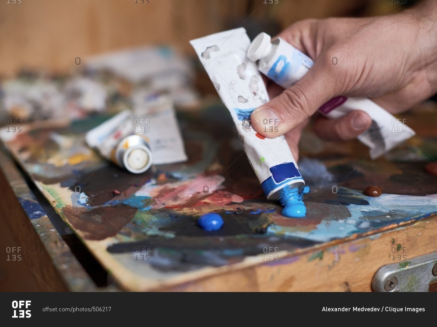 Process of creating art close up view of male hand squeezing blue oil