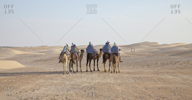 Group of people on camels in desert