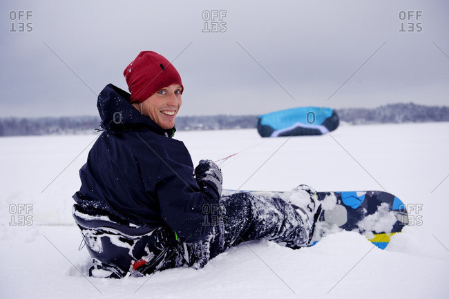 Man with snowboard holding parachute