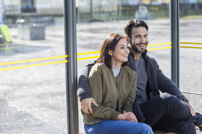 Mid adult couple on bus stop stock photo - OFFSET