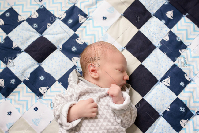 Baby asleep on checkered quilt