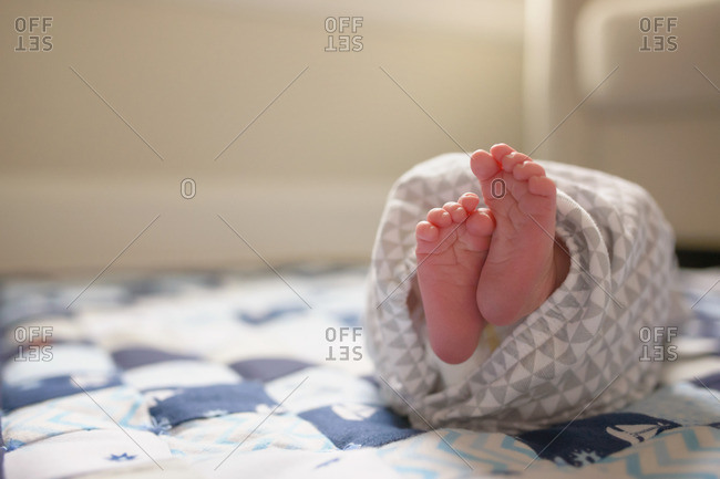 Baby with bare feet on quilt