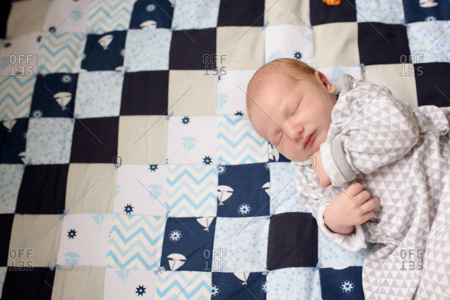Baby asleep on a checkered quilt