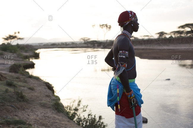 Samburu tribesman, standing by river in early morning light, Kenya