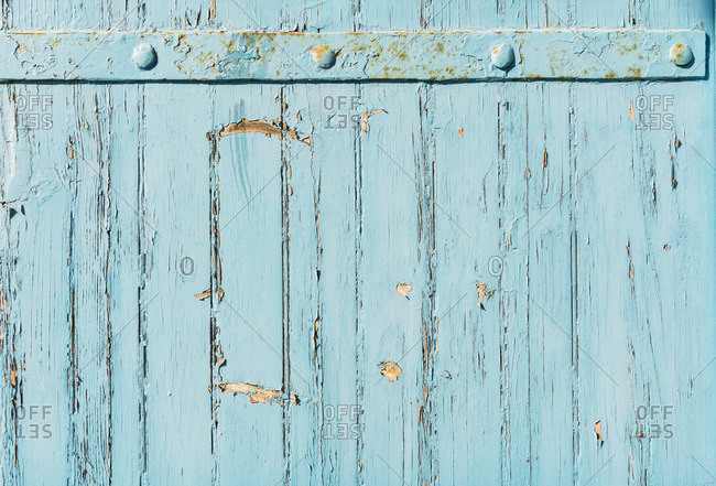 Close up of old wood with worn blue paint and rusty nails