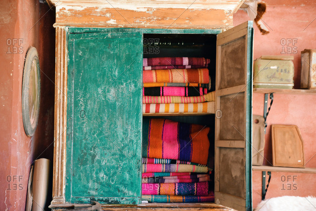 Stacks of folded woven textiles in a cabinet