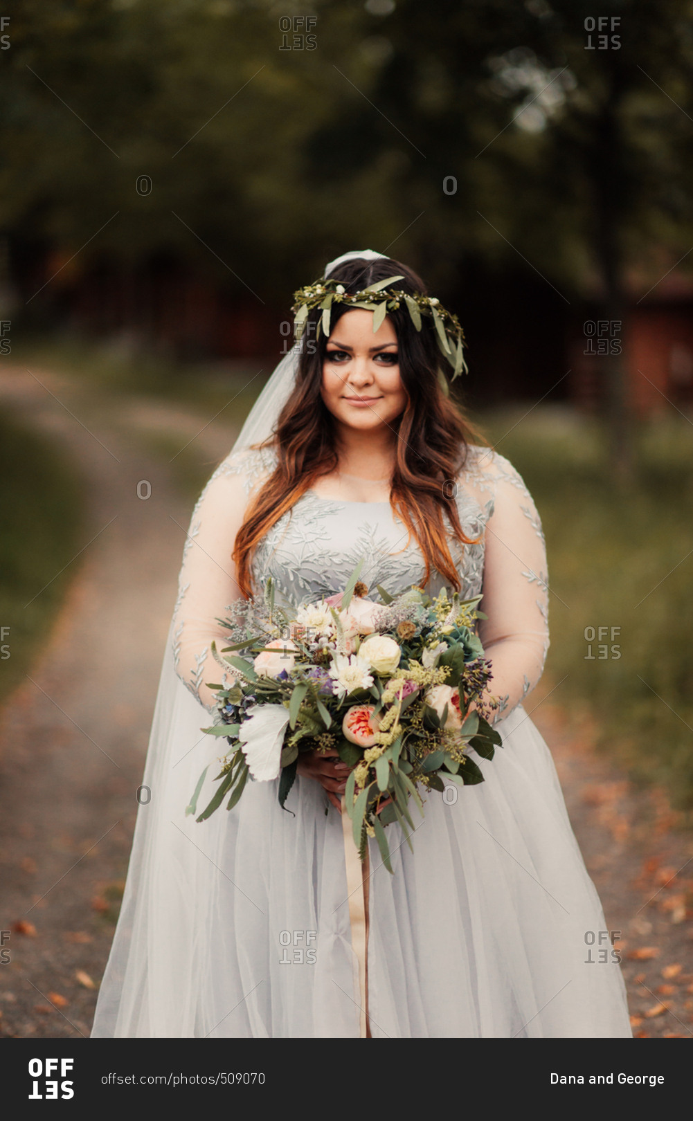 Bride with her bouquet on rural path