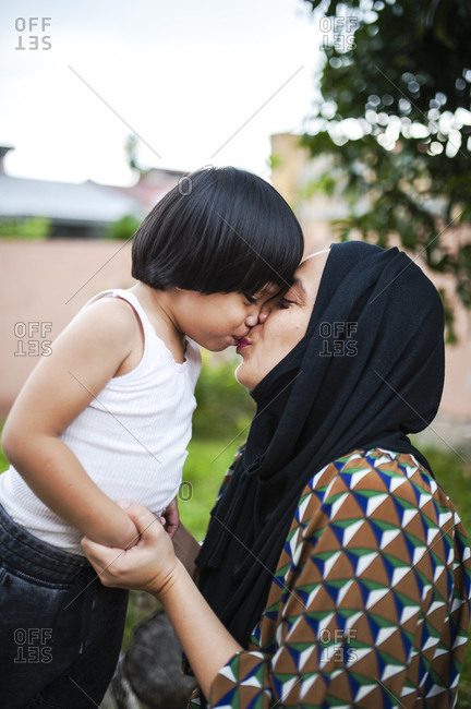 Mother giving her son a kiss outdoors