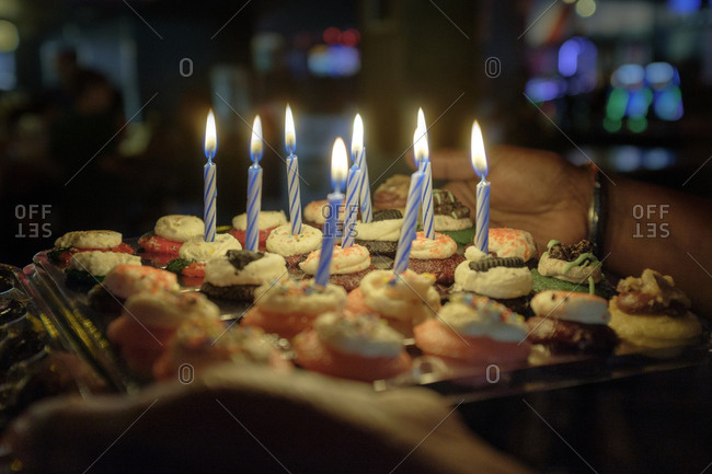 Person Holding Tray Of Cupcakes With Birthday Candles Stock Photo