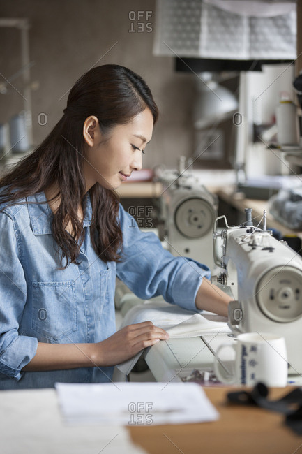 Fashion designer working with sewing machine in studio