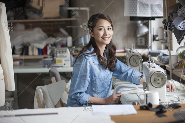 Fashion designer working with sewing machine in studio