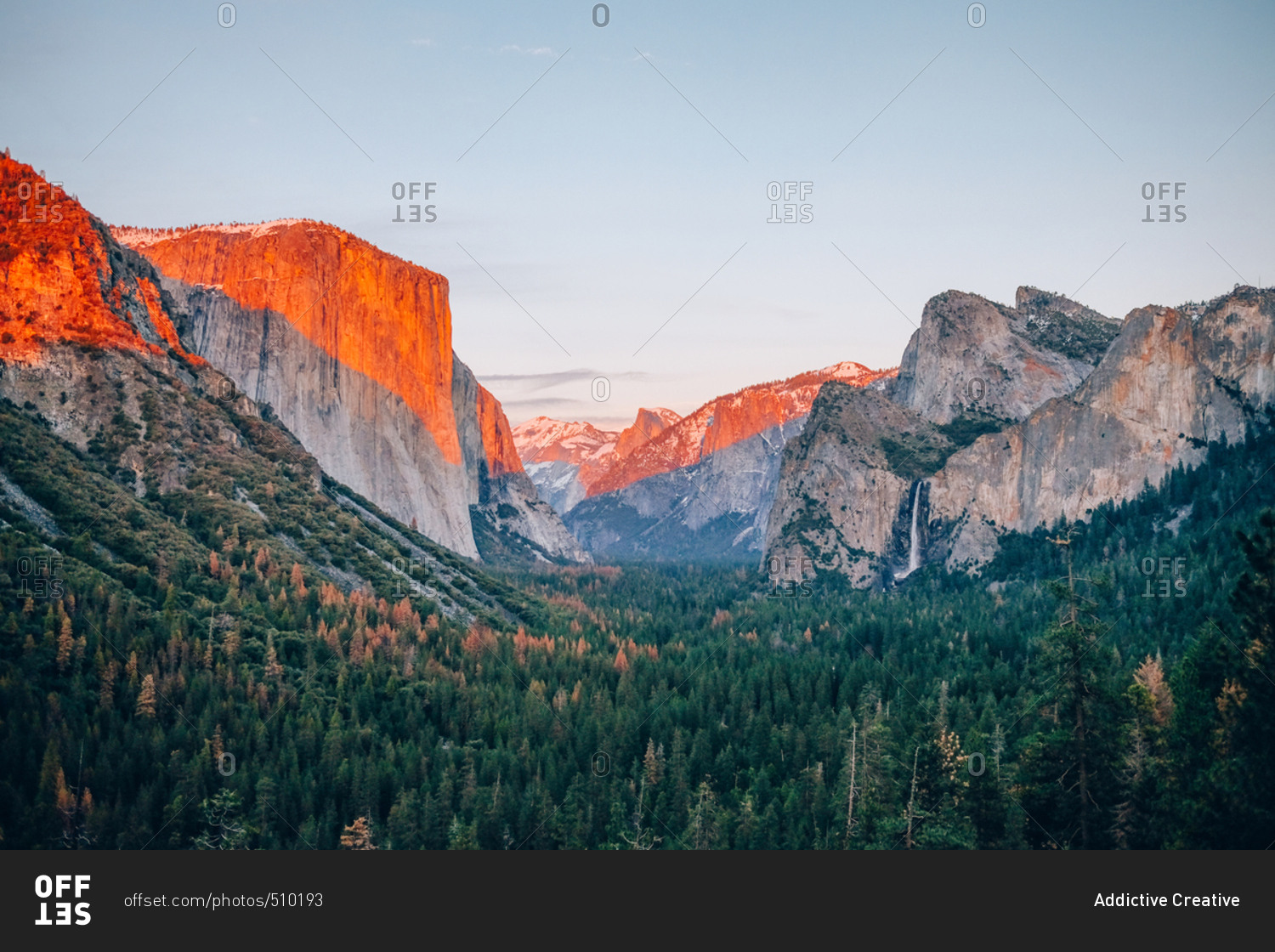 Famous Yosemite national park with rocky mountains on blue sky at sunrise.