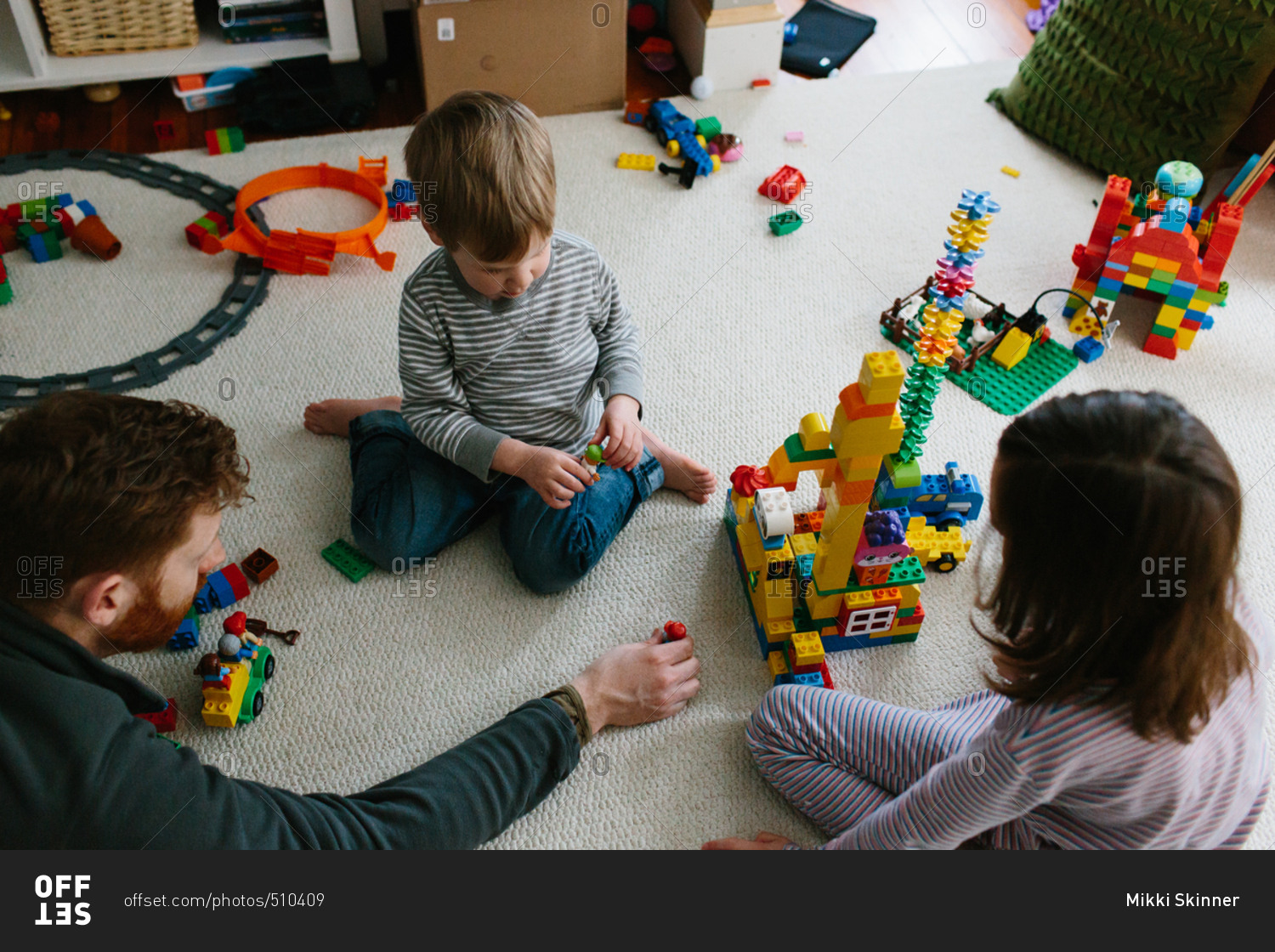 Father playing with building blocks with his son and daughter
