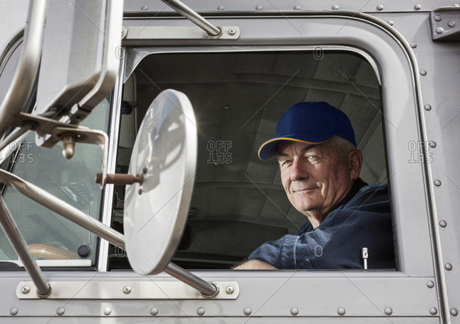 Caucasian trucker sitting in semi-truck