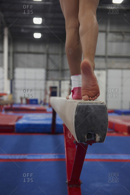 Caucasian gymnast practicing on high beam