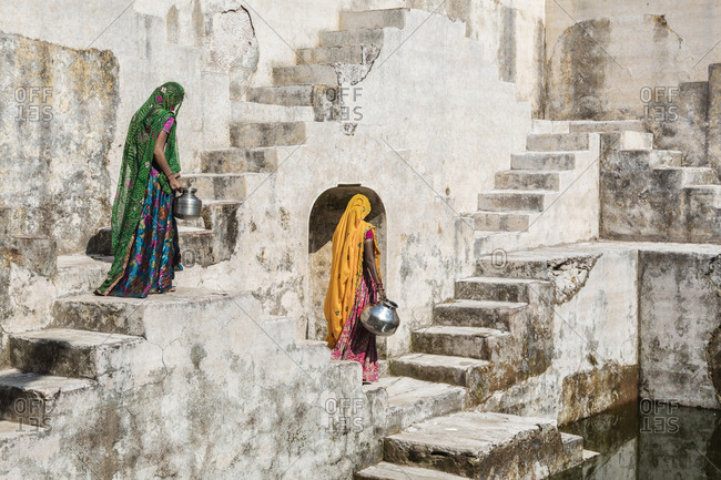 Women in saris carrying water at step well, Jaipur, Rajasthan, India