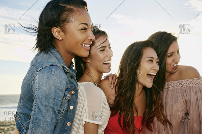 Women smiling together on beach
