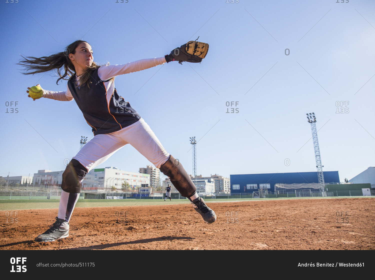 Female baseball player throwing the ball during a baseball game