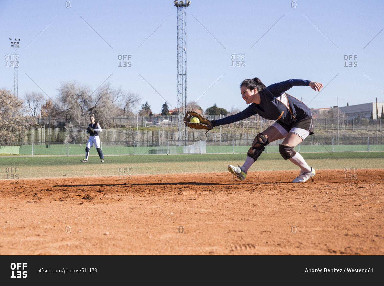 Female baseball player catching the ball during a baseball game