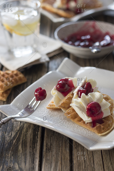Plate of waffles with whipped cream- cherries and cherry groats
