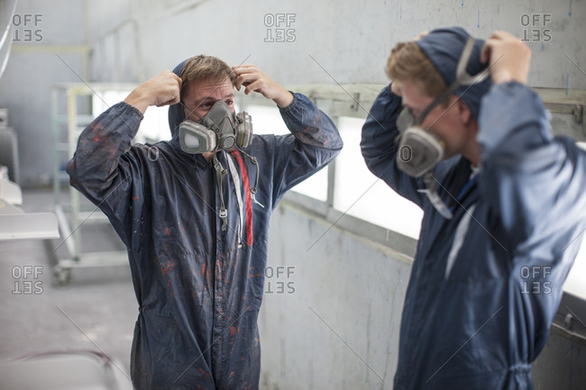 Factory worker in truck manufacture adjusting respirators