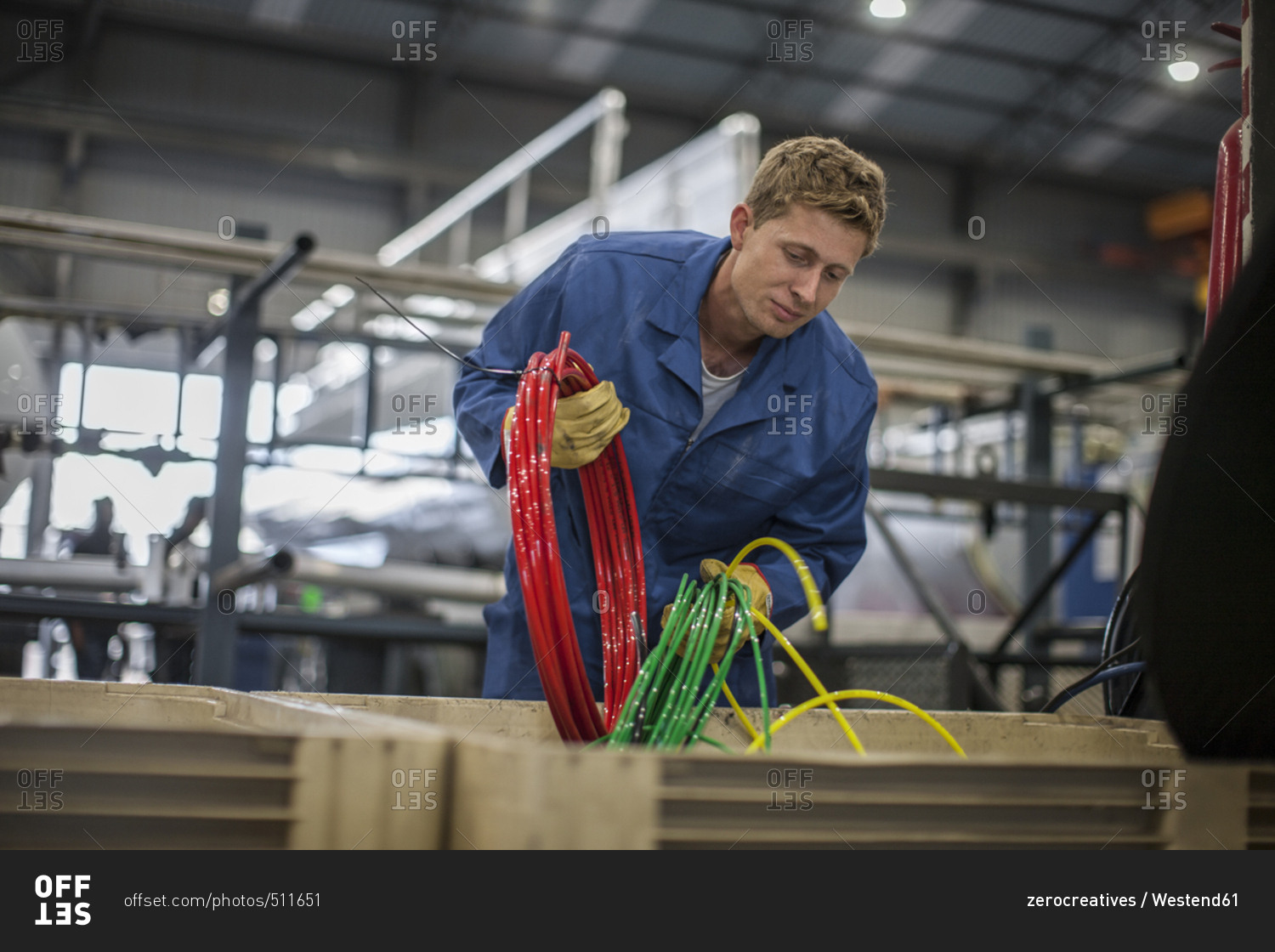 Factory worker in truck manufacture sorting cables in to box
