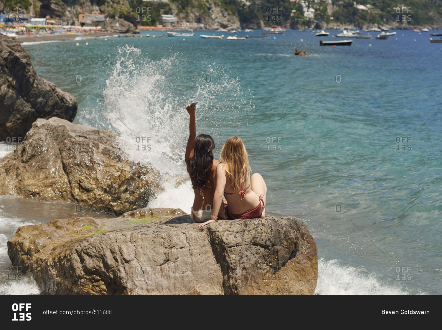 Beautiful carefree girl friends arms raised in bikini on beach sea lifestyle fun summer adventure vacation