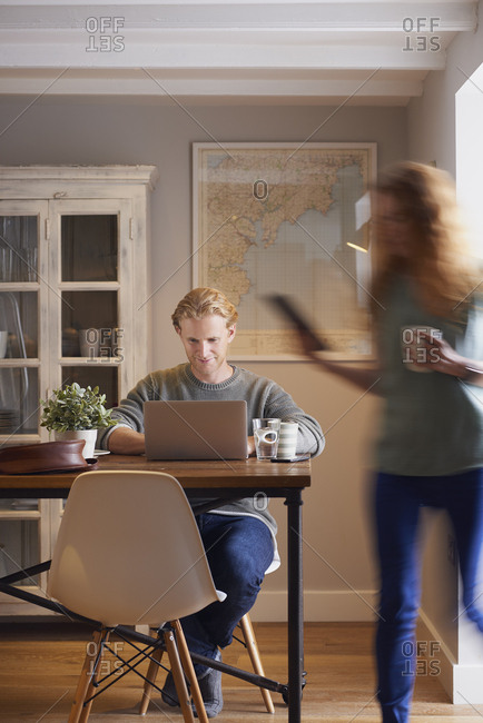 August 1, 2016: Attractive man woman couple using laptop digital tablet technology at home browsing internet network