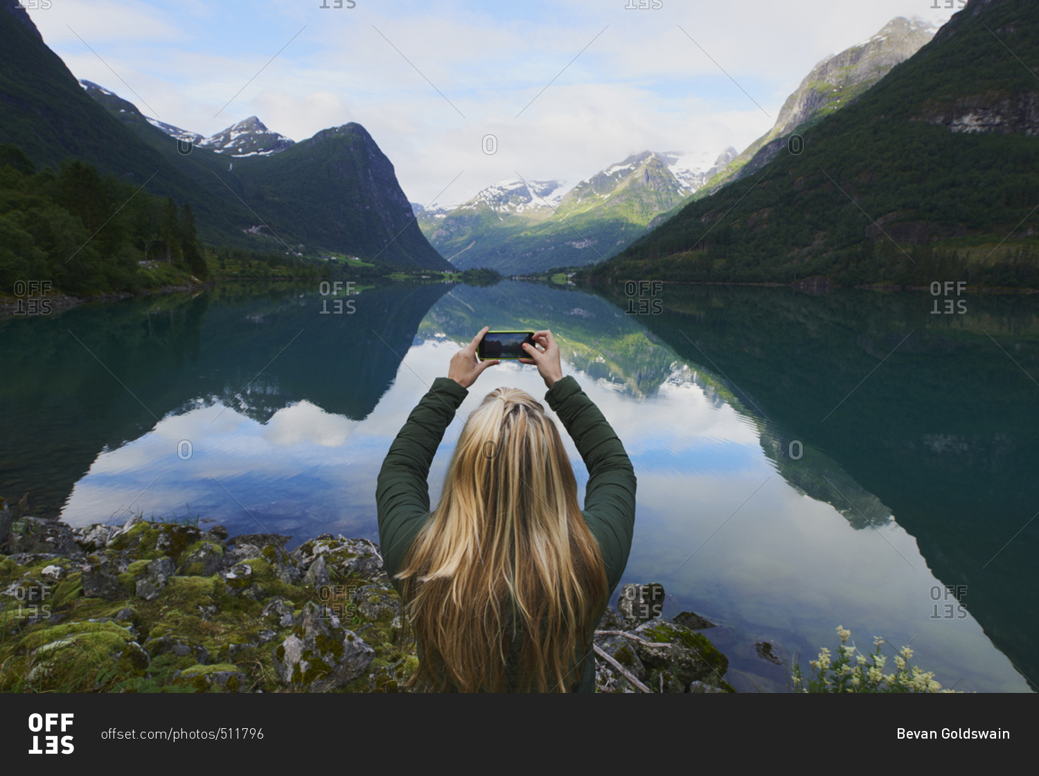 Adventure woman taking photo of beautiful nature mountail lake with smart phone travel explore discover