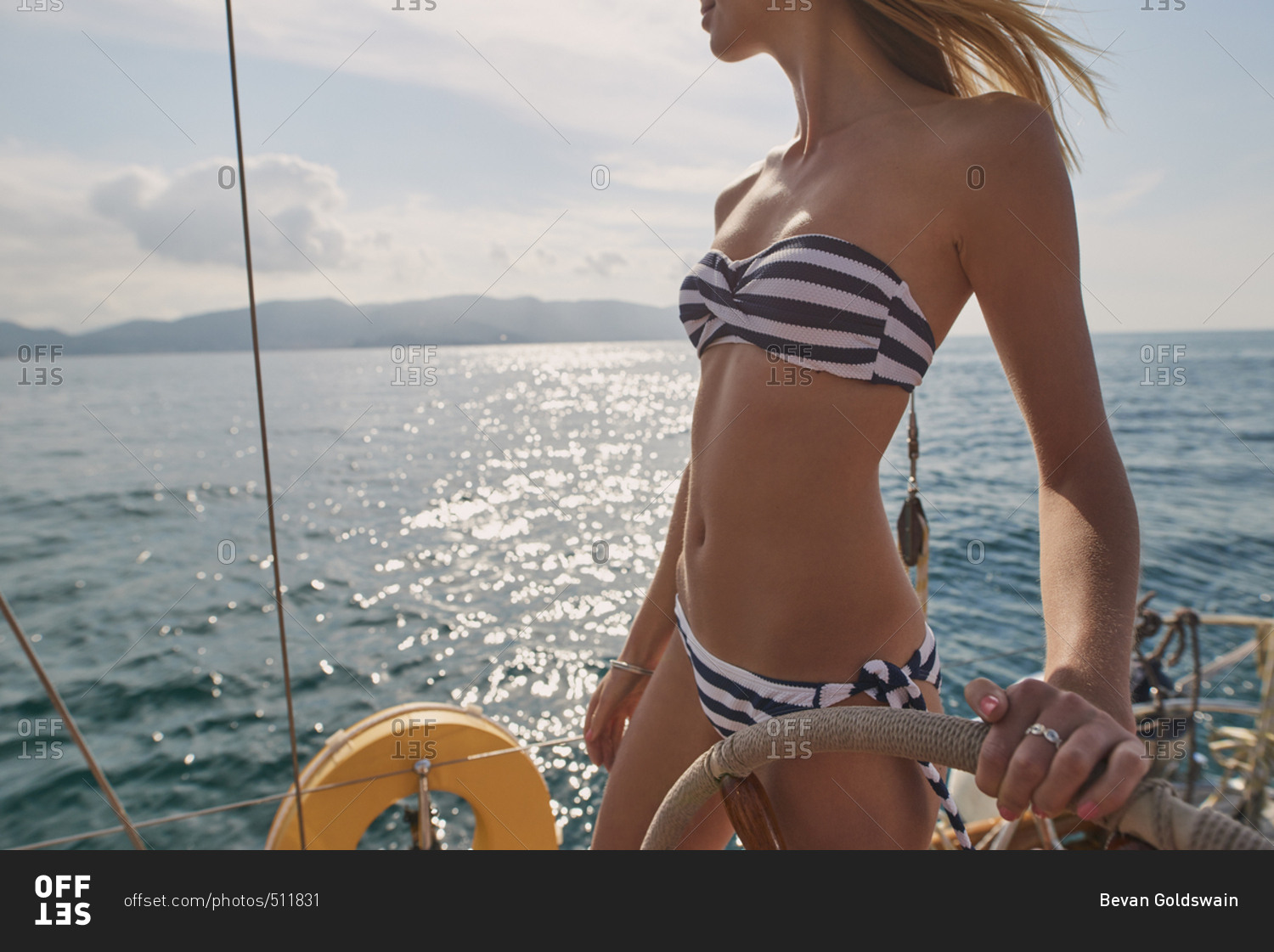 Beautiful sexy woman steering luxury sailboat in ocean on lifestyle happy adventure travel vacation