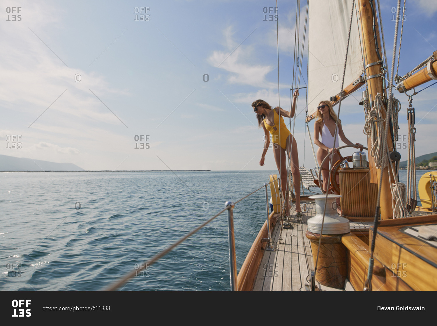 Beautiful fashion sexy women steering luxury sailboat in ocean on lifestyle happy adventure travel vacation
