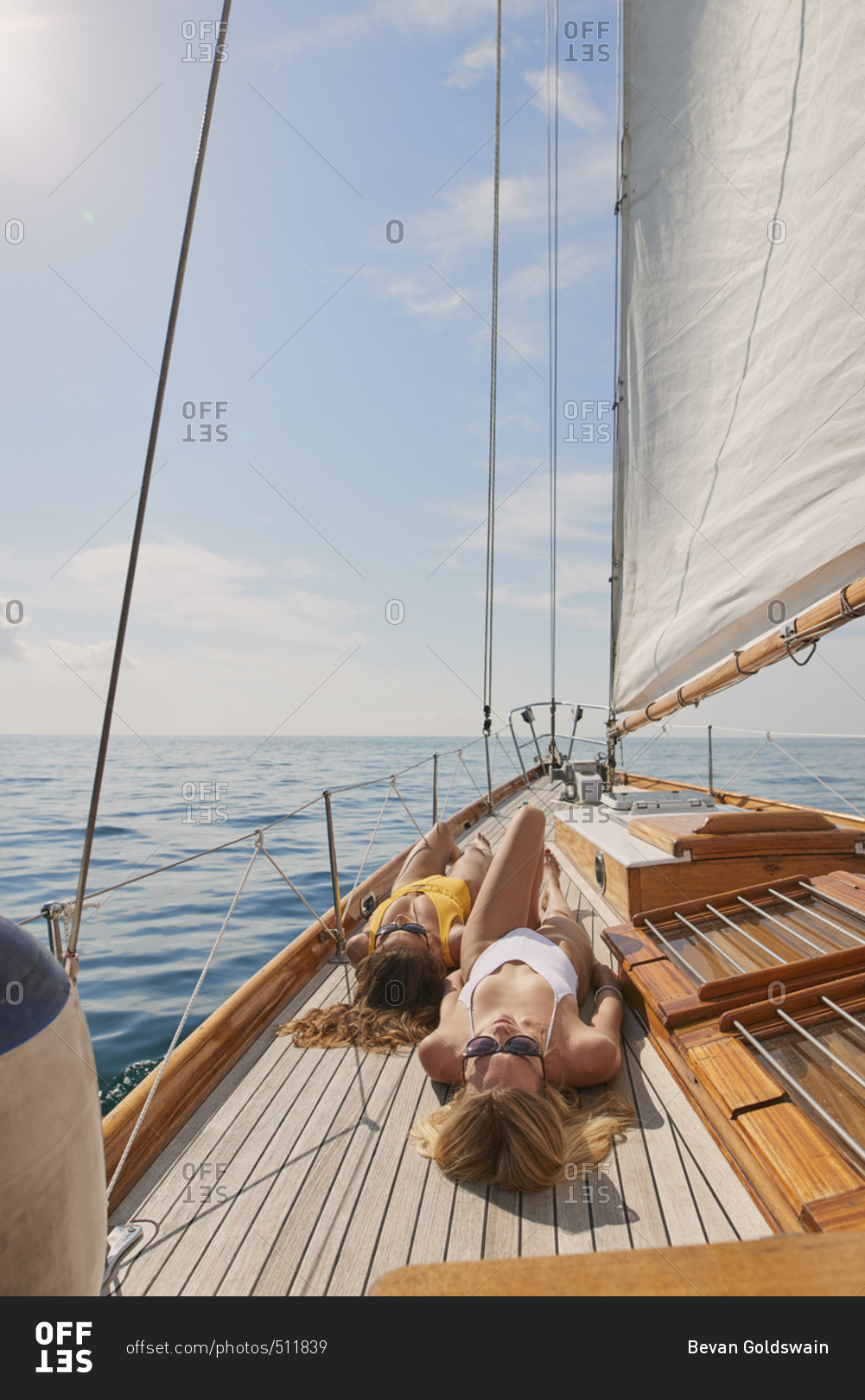 Beautiful women sunbathing on sailboat in ocean on luxury lifestyle happy adventure travel vacation