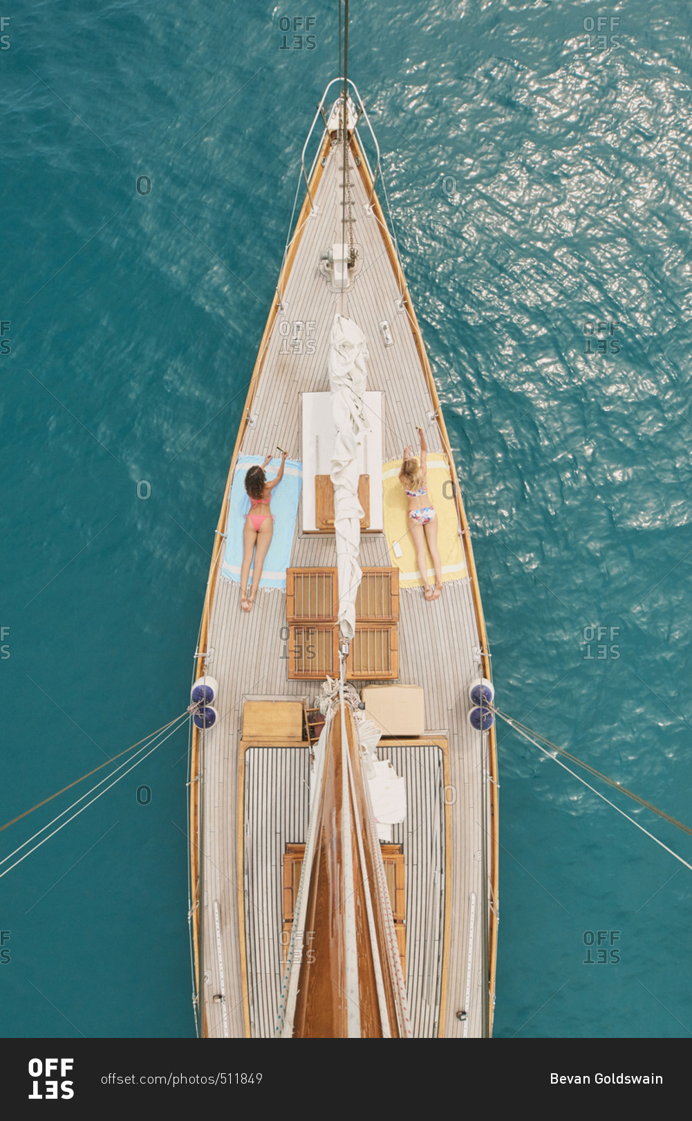 Beautiful girl friends on sailboat in ocean from above overhead on luxury lifestyle adventure travel vacation