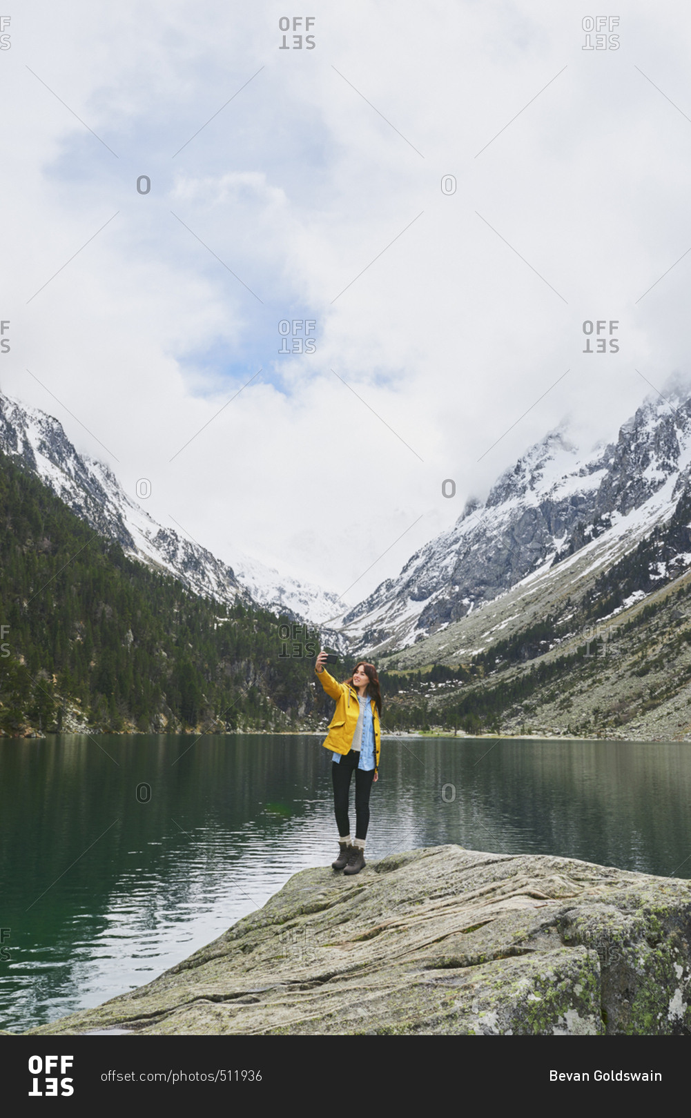 Travel adventure woman taking smart phone selfies on mountain lake enjoying beautiful nature landscape wanderlust