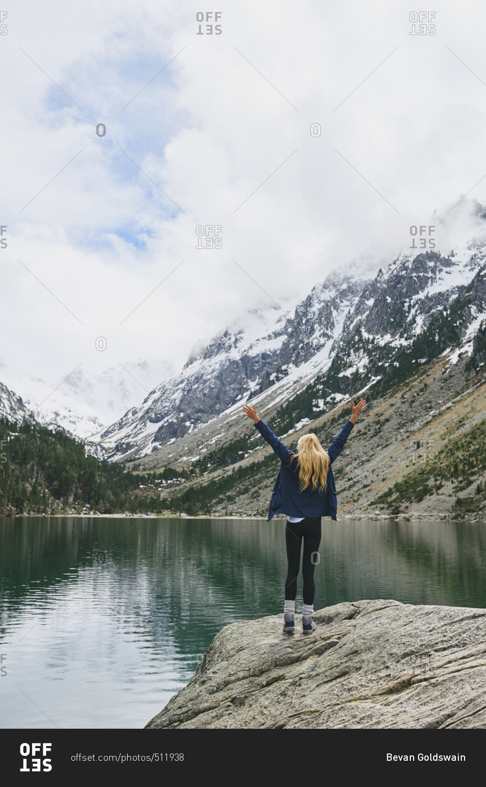 Travel adventure hiker woman celebrates on mountain lake arms outstretched enjoying beautiful nature landscape wanderlust