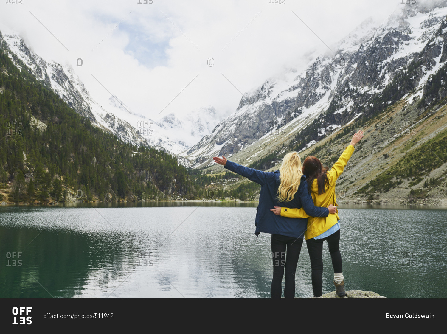 Travel adventure hiker woman friends celebrate on mountain lake arms outstretched enjoying beautiful nature landscape wanderlust