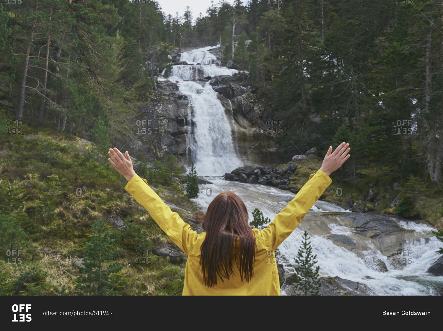 Travel adventure hiker woman celebrates arms outstretched at waterfall enjoying beautiful nature landscape wanderlust