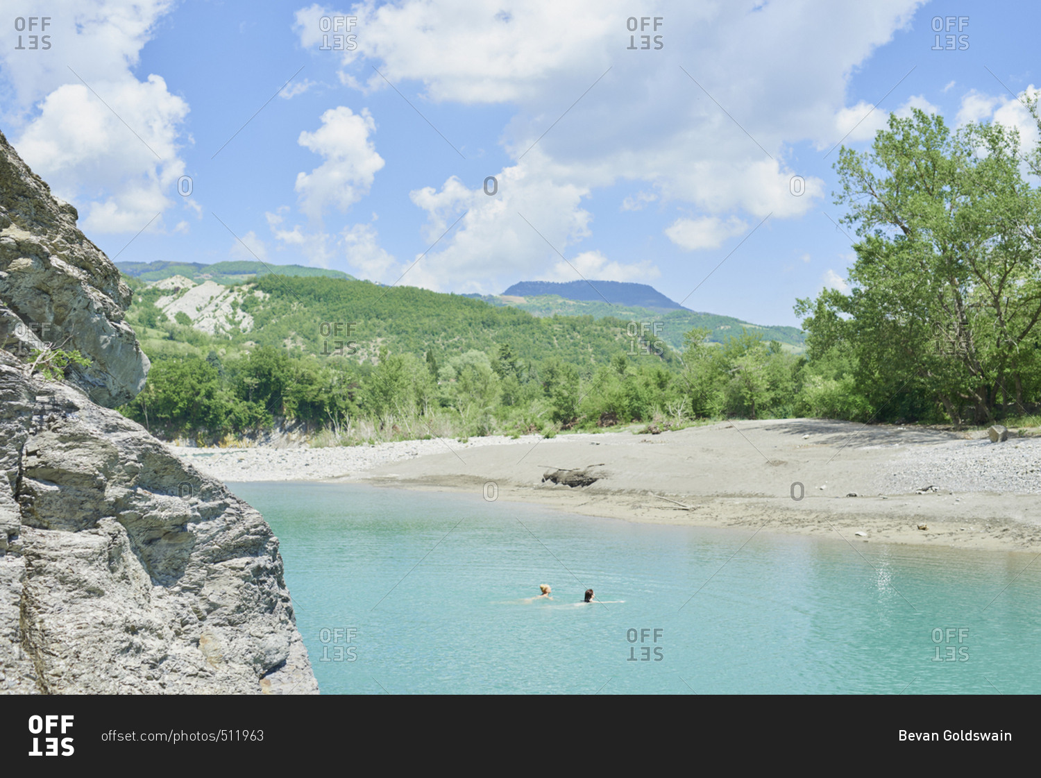 Girl friends wild swimming in beautiful blue freshwater river on travel adventure