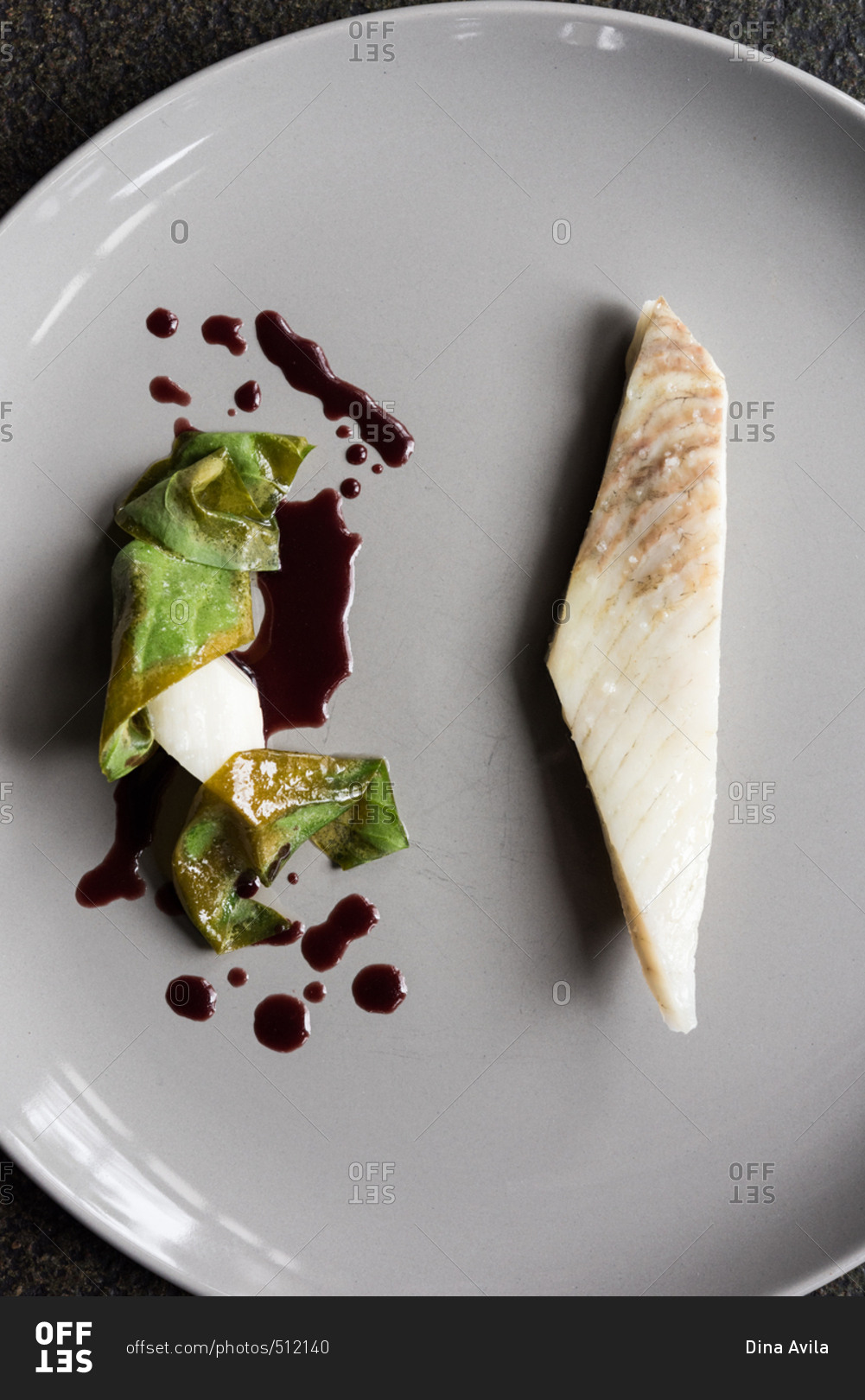 Minimalist plating of fish and vegetable with soy sauce stock photo
